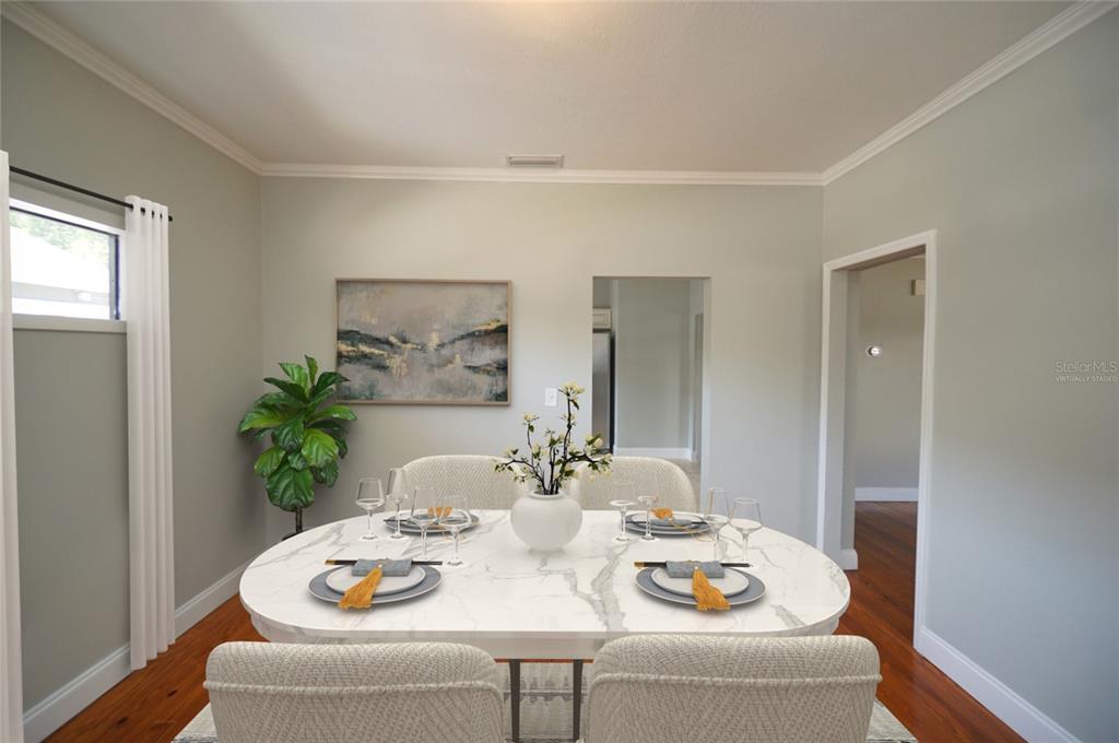 A dining room with a marble-topped table, four chairs, and hardwood floors — 916 E 25TH AVENUE, TAMPA, FL