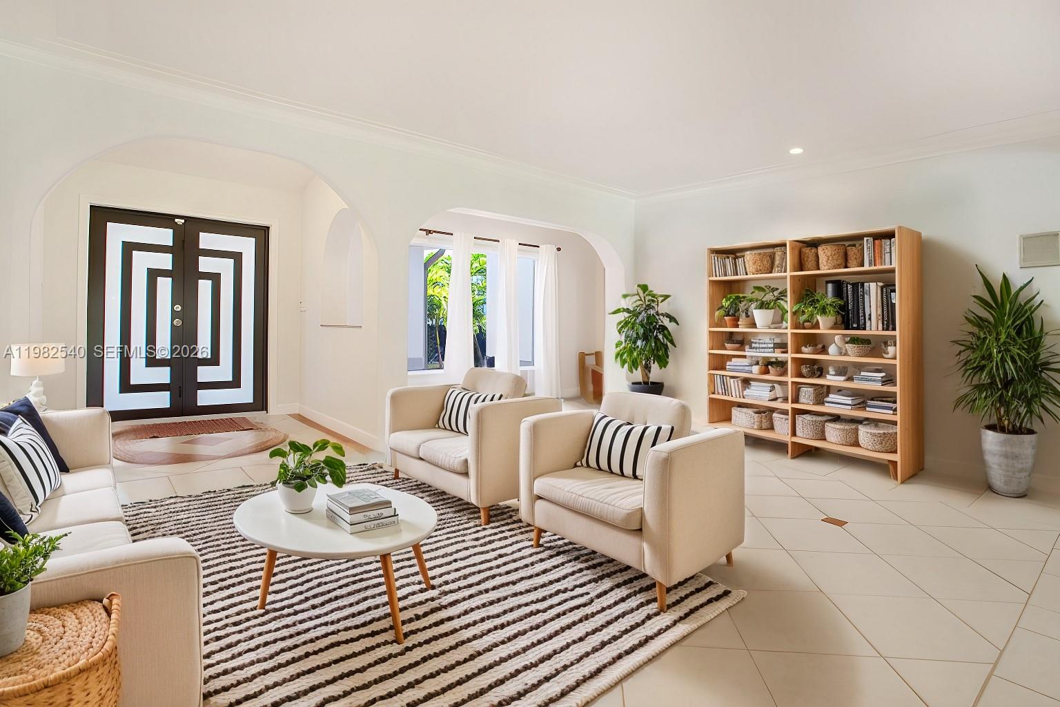 A living room features light tile floors, a striped rug, and a wooden bookshelf — 100 SW 26th Rd, Miami FL 33129, MIAMI, FL