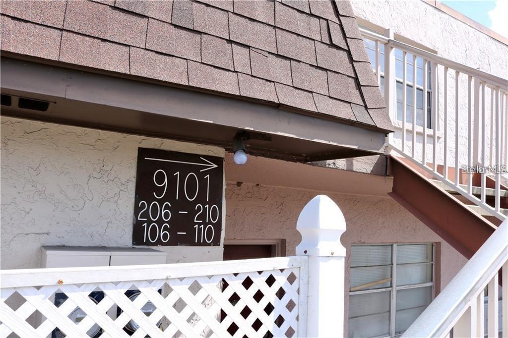 An exterior view shows a building sign with unit numbers and a staircase — 9101 W HILLSBOROUGH AVENUE UNIT I207, TAMPA, FL