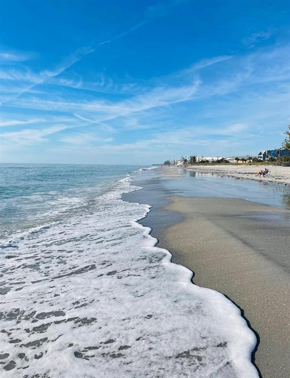 A view of a sandy beach with ocean waves washing onto the shore under blue skies — 15610 VISCOUNT CIRCLE, PORT CHARLOTTE, FL