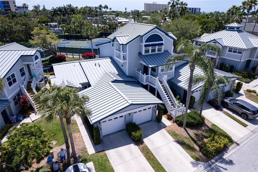 An aerial view of a multi-story house with a metal roof and attached garages — 1220 SIESTA BAYSIDE DRIVE UNIT 1220-A, SARASOTA, FL