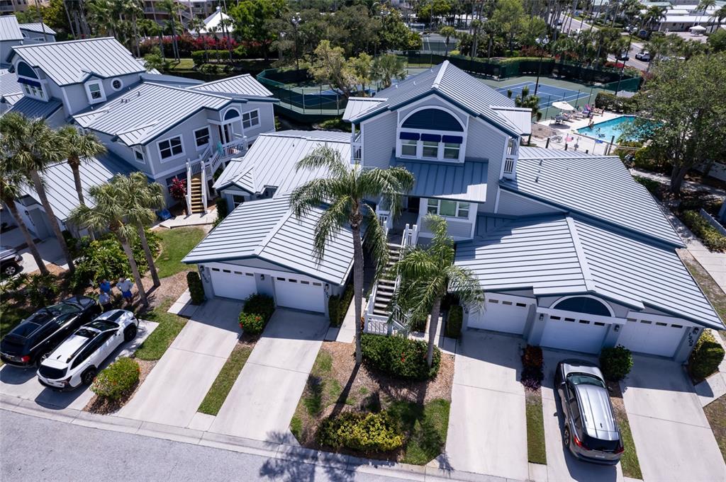 An aerial view shows a multi-unit residential building with metal roofs and attached garages — 1220 SIESTA BAYSIDE DRIVE UNIT 1220-A, SARASOTA, FL