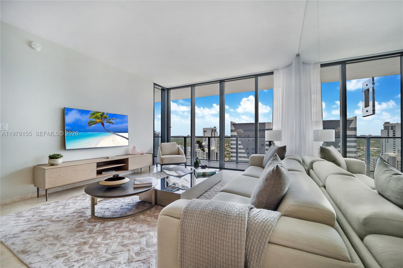 A modern living room features a large sectional sofa, coffee tables, and floor-to-ceiling windows — 88 SW 7th St # 1810, Miami FL 33130, MIAMI, FL