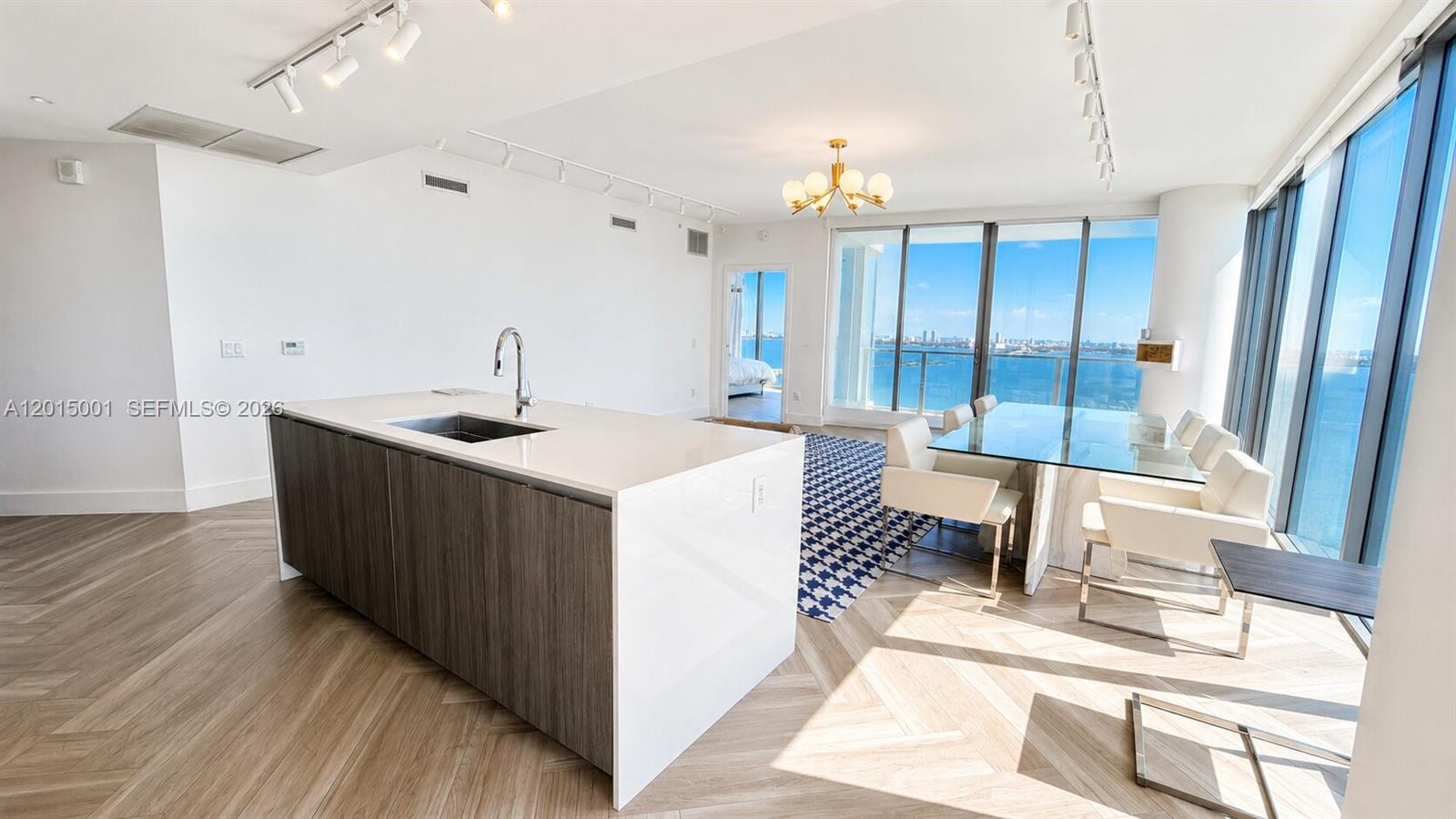 A modern kitchen island with a sink sits in an open-concept room with water views — 2900 NE 7th Ave # 3207, Miami FL 33137, MIAMI, FL