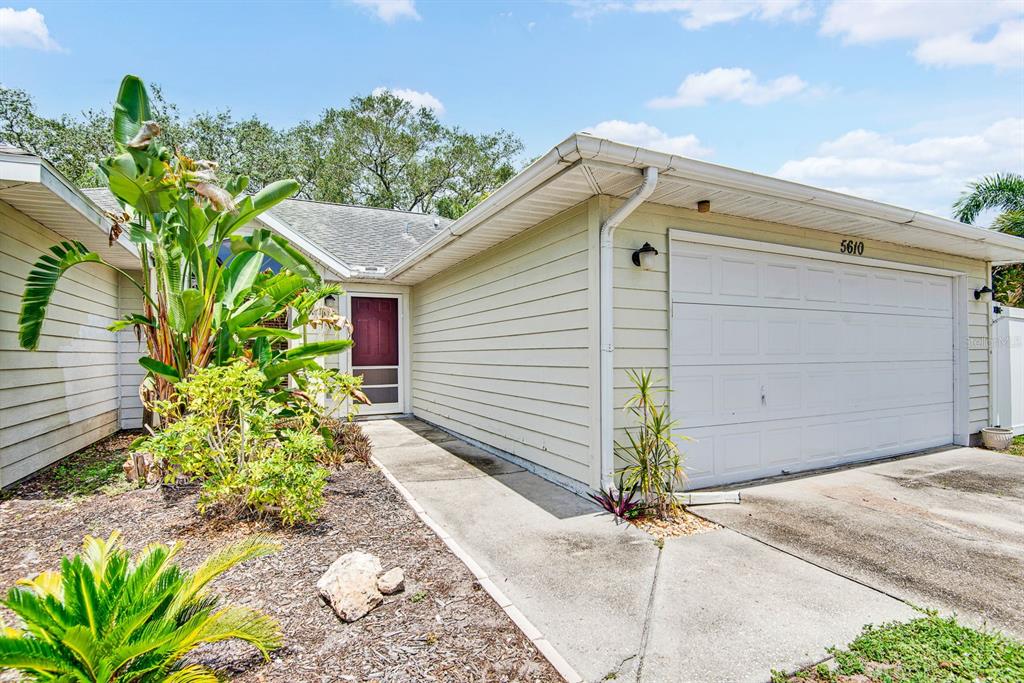 The exterior of a single-story house features light-colored siding, a garage, and a front entrance — 5610 33RD LANE E, BRADENTON, FL