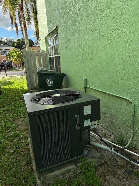 An outdoor air conditioning unit sits on a concrete pad next to a green wall — 4172 Pine Hollow Circle, FL 33463, FL
