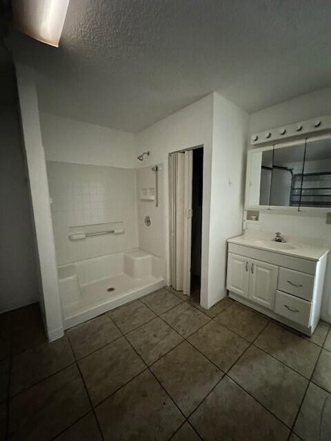 A bathroom featuring a white shower stall, a vanity with a mirror, and tiled flooring — 4172 Pine Hollow Circle, FL 33463, FL