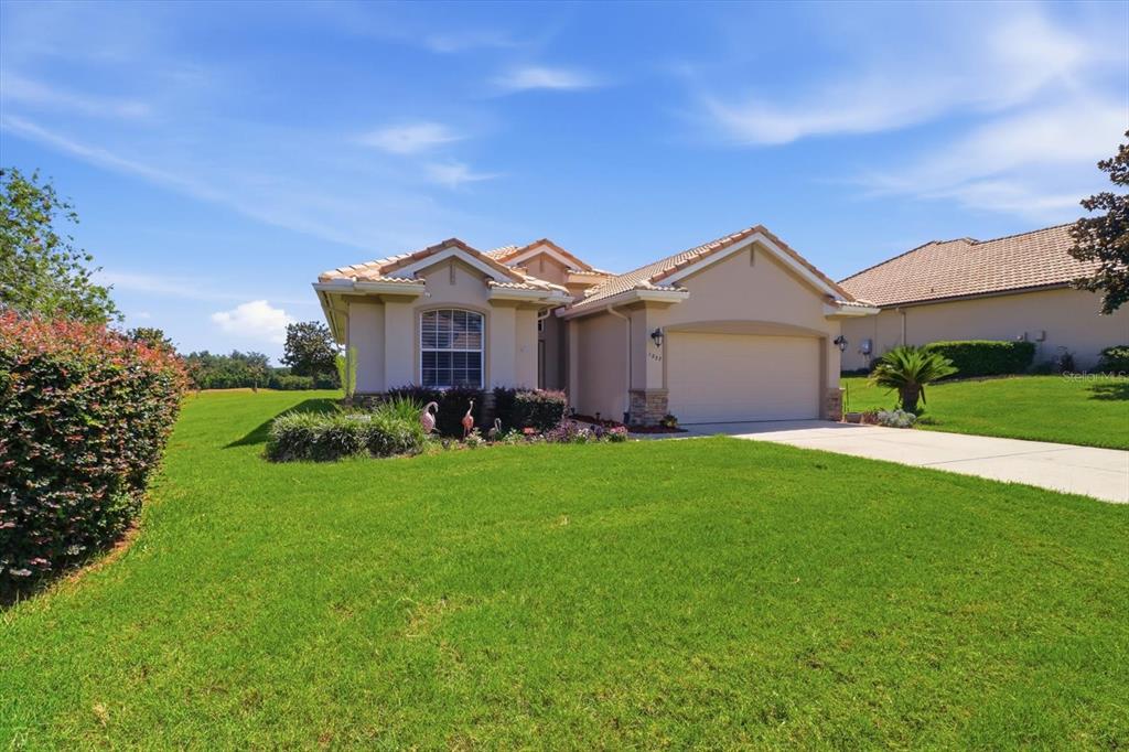 A single-story suburban house with a tan stucco exterior, tile roof, and attached garage — 1257 W SKYVIEW CROSSING DRIVE, HERNANDO, FL