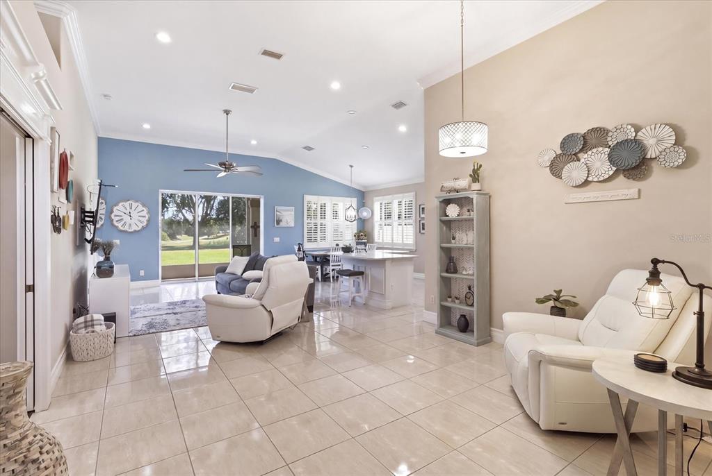 An open-concept living and dining area features light tile floors, blue accent walls, and furniture — 1257 W SKYVIEW CROSSING DRIVE, HERNANDO, FL