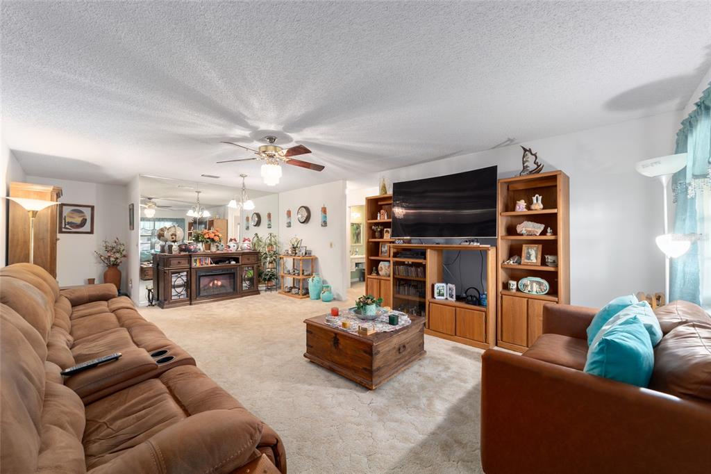 A living room features brown sofas, a wooden coffee table, and a large media console — 9233 SW 83RD TERRACE UNIT D, OCALA, FL