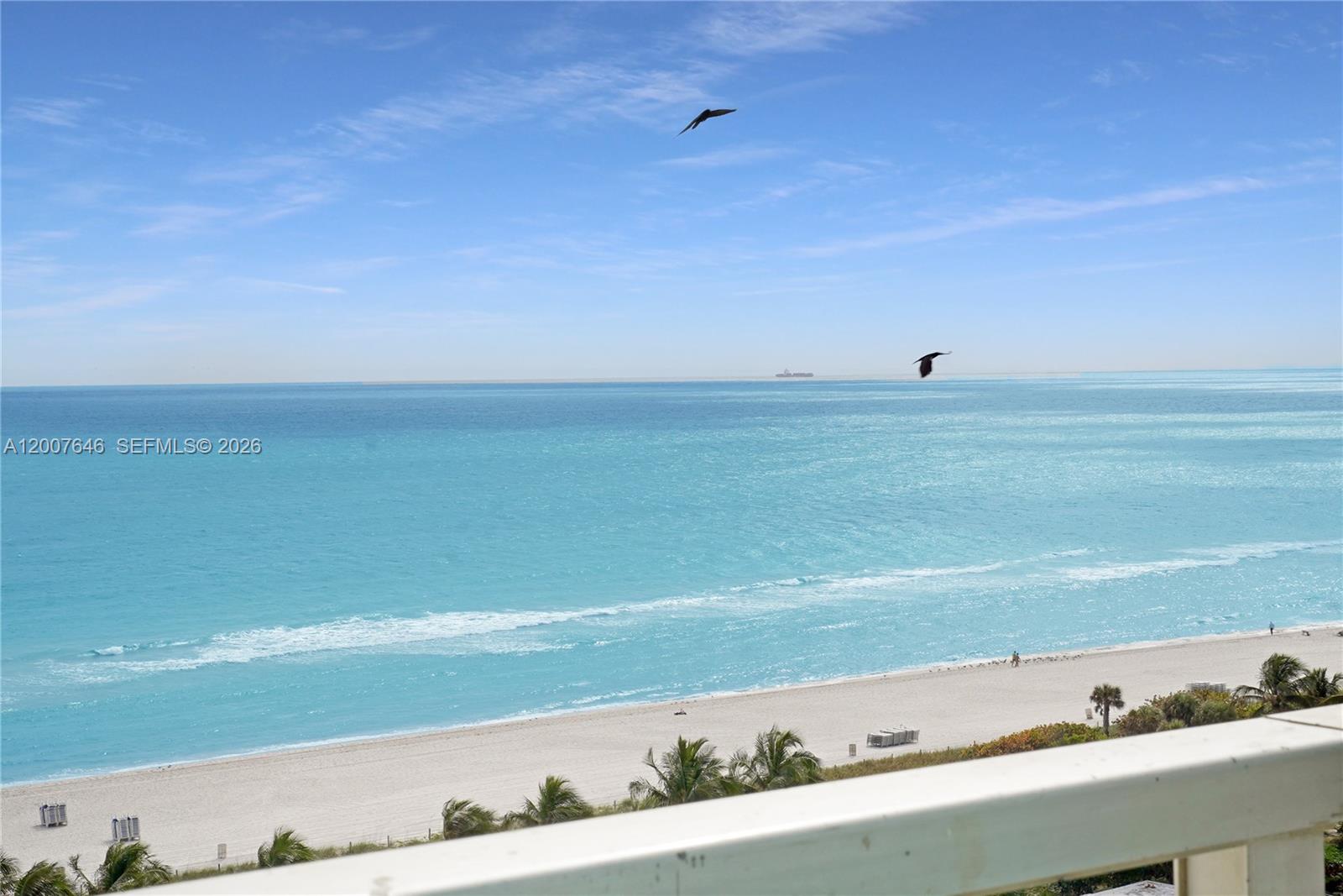 An elevated view of a sandy beach and turquoise ocean under a clear blue sky — 5101 Collins Ave # 14F, Miami Beach FL 33140, MIAMI BEACH, FL