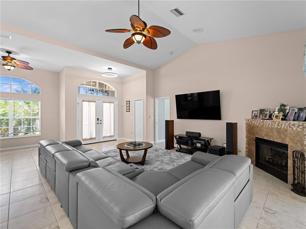 A living room features a large grey sectional, a fireplace, and a vaulted ceiling — 2288 PRAGUE LANE, PUNTA GORDA, FL