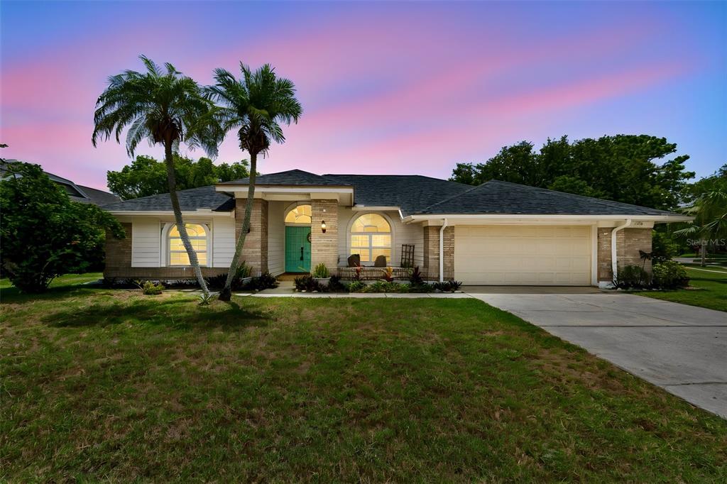 A single-story house with a brick and siding exterior, a two-car garage, and palm trees — 1776 WOOD THRUSH WAY, PALM HARBOR, FL