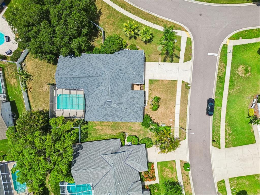 An aerial view shows two houses with swimming pools and driveways in a suburban neighborhood — 1776 WOOD THRUSH WAY, PALM HARBOR, FL