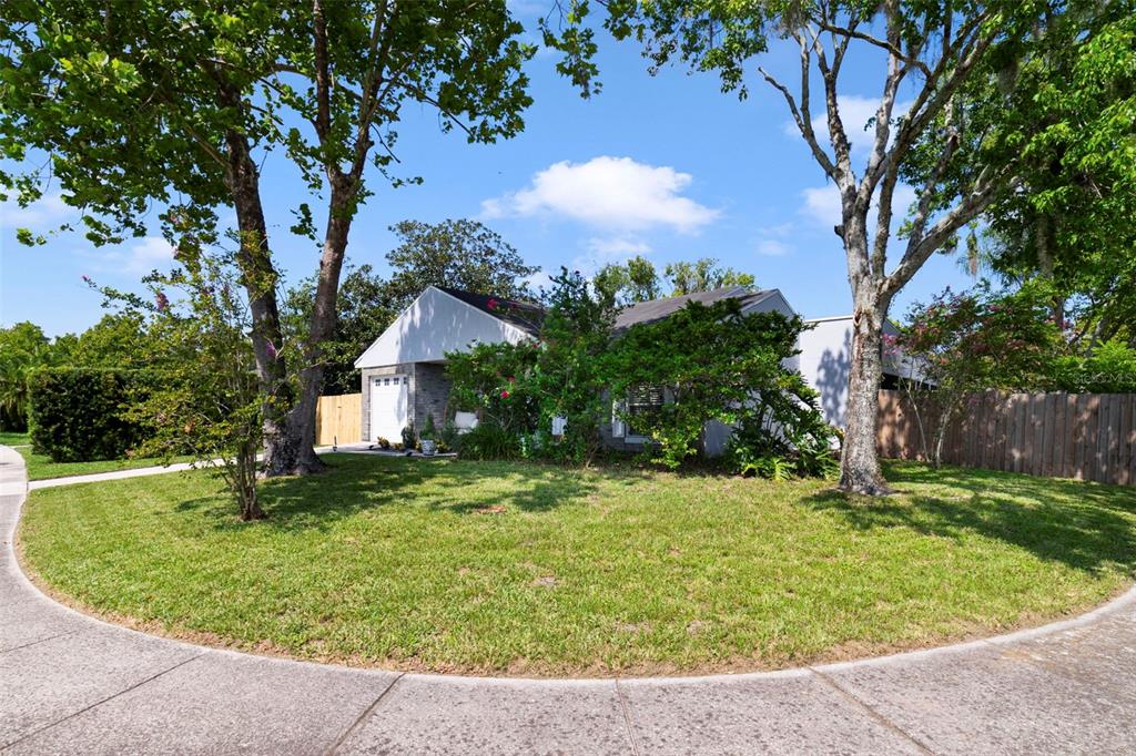 A single-story house with a white garage and gray siding sits behind a grassy lawn — 13953 FOX MEADOW DRIVE, ORLANDO, FL