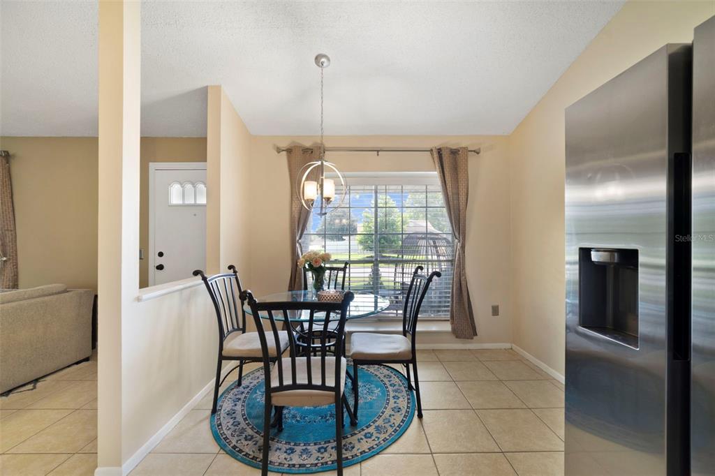 A dining area features a glass table, four chairs, a blue rug, and a pendant light — 13953 FOX MEADOW DRIVE, ORLANDO, FL
