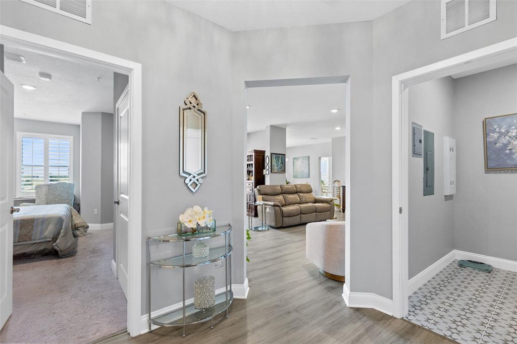A hallway with light gray walls leads to a living room and a bedroom — 7521 LAUREATE BOULEVARD UNIT 5307, ORLANDO, FL