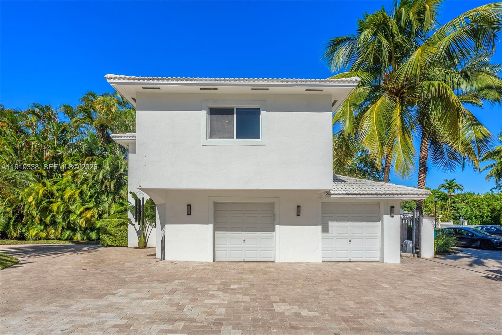 A two-story white house features a two-car garage and a paved driveway under palm trees — 6300 Allison Rd, Miami Beach FL 33141, MIAMI BEACH, FL