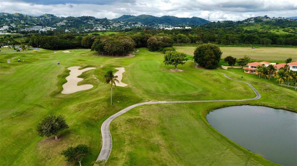 An aerial view of a golf course featuring a sand bunker, pond, and nearby houses — ACADEMY DRIVE, HUMACAO, PR