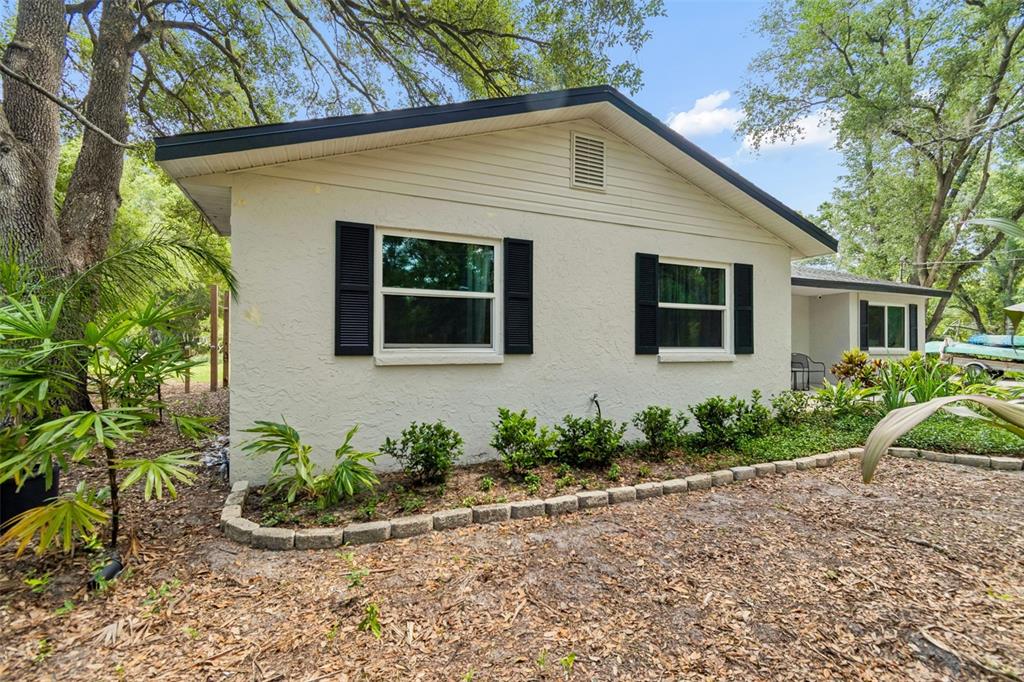 A single-story house with a light-colored exterior, black shutters, and a stone walkway — 6214 15TH AVENUE S, TAMPA, FL