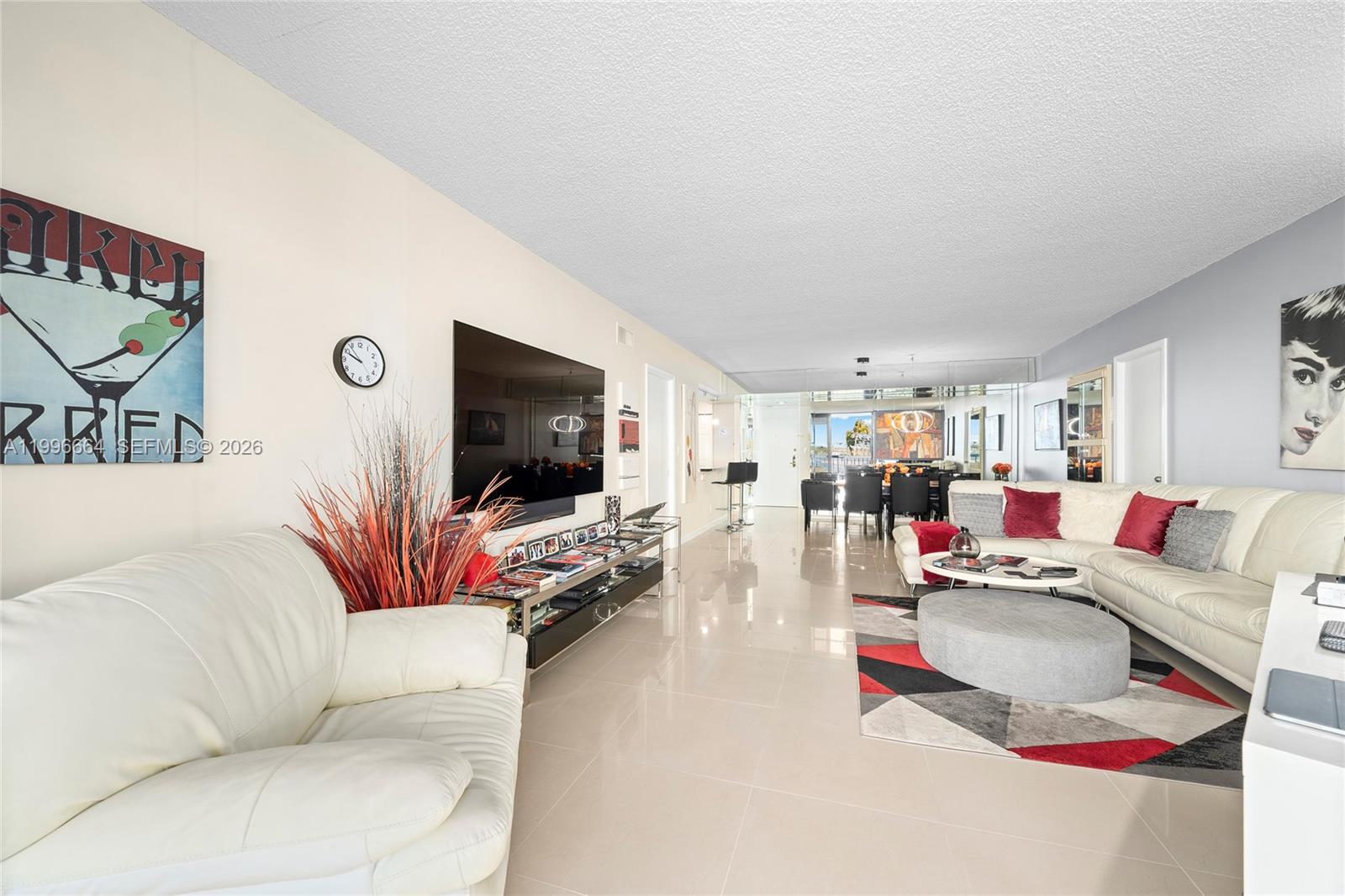 A living room features white leather sofas, a large television, and a geometric area rug — 3300 S Ocean Blvd # 207N, Palm Beach FL 33480, PALM BEACH, FL