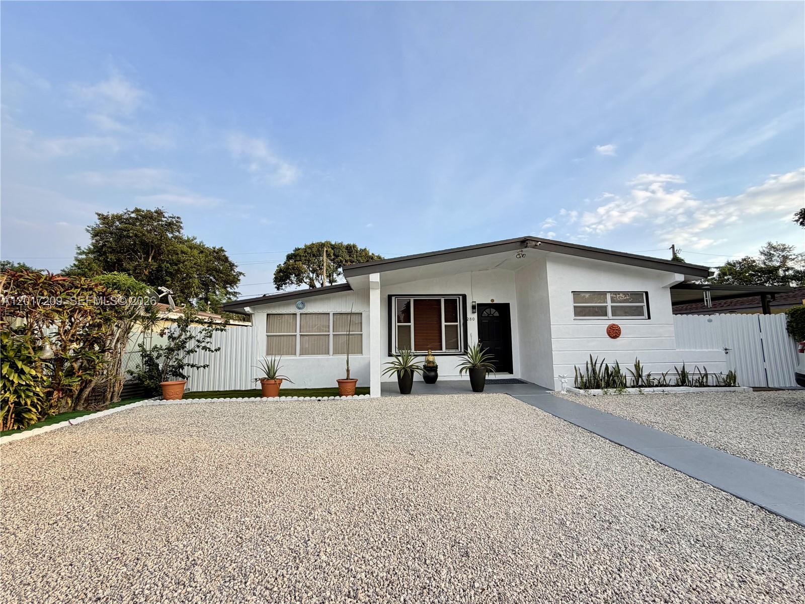 A white single-story house features a gravel front yard and a concrete walkway — 280 NE 173rd St, North Miami Beach FL 33162, NORTH MIAMI BEACH, FL