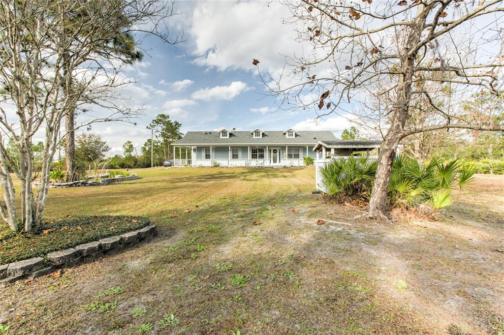 A single-story house with a covered porch and three dormer windows sits on a lawn — 20351 SABAL STREET, ORLANDO, FL