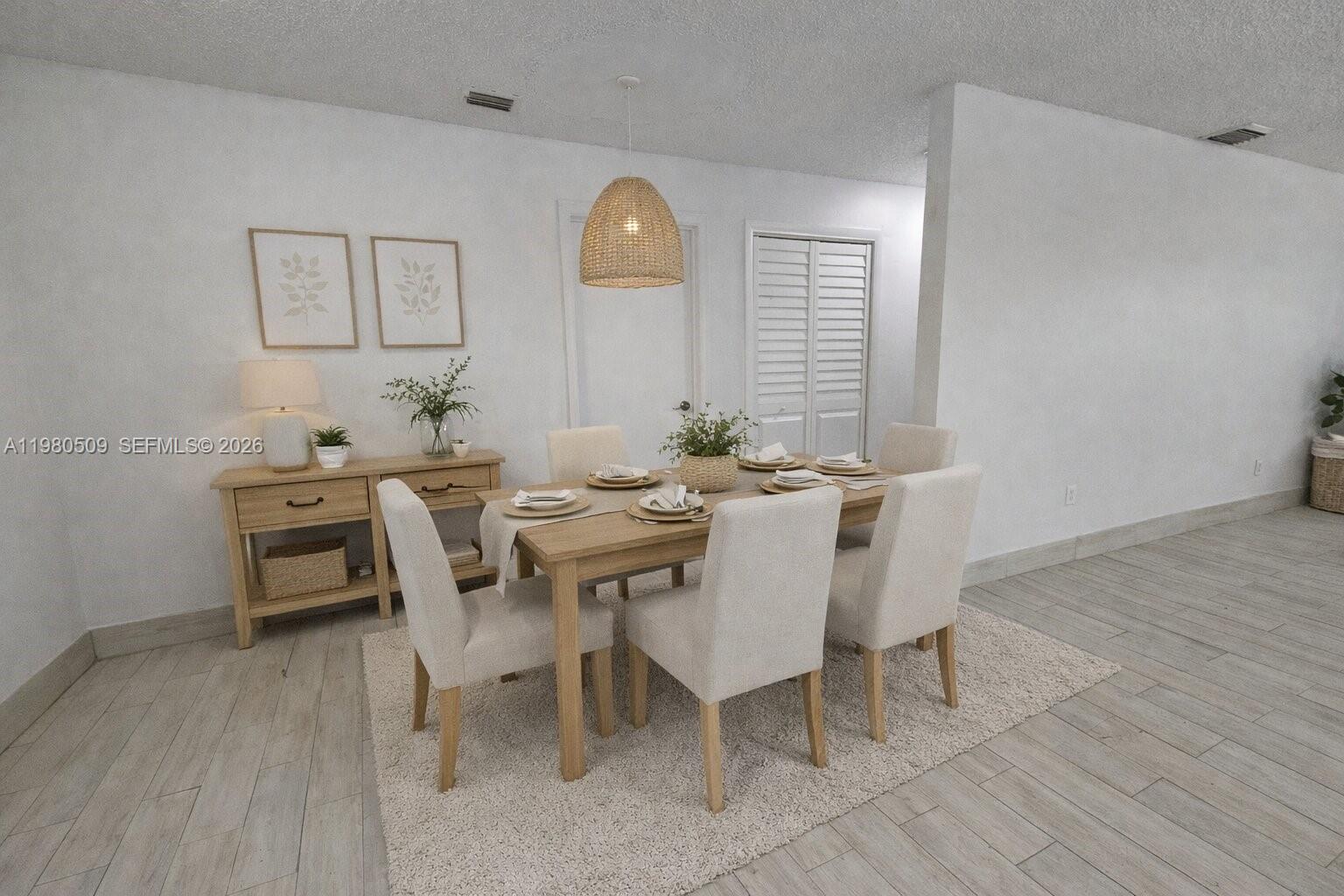 A dining room features a wooden table, upholstered chairs, a woven pendant light, and flooring — 4621 SW 33rd Ave # 1, Dania Beach FL 33312, DANIA BEACH, FL