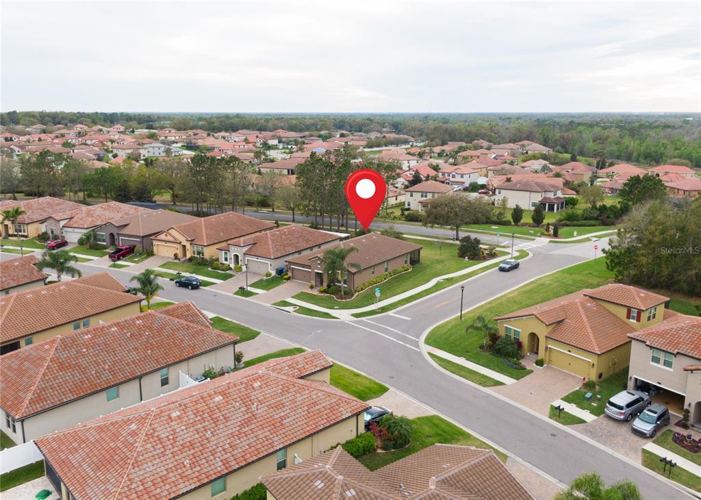 An aerial view shows a suburban neighborhood with single-family homes and paved streets — 4004 PRIMA LAGO CIRCLE, LAKELAND, FL
