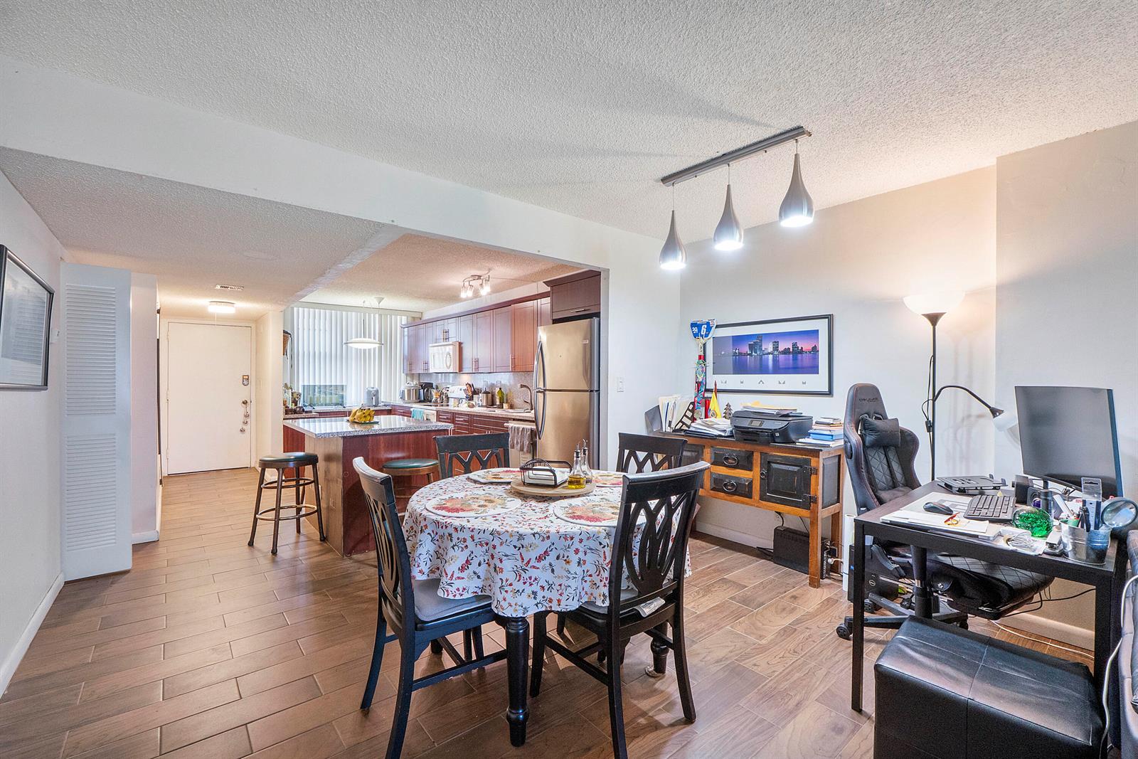 An open-concept dining area and home office feature tile flooring and modern pendant lighting — 250 Jacaranda Drive # 308, Plantation FL 33324, PLANTATION, FL