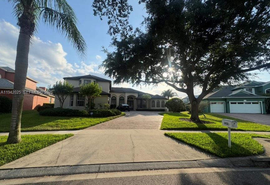 A two-story house with a paved driveway and a large tree in the front yard — 10020 Honey Tree Ct, Orlando FL 32836, ORLANDO, FL