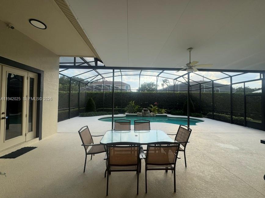 A covered patio features a dining set overlooking a screened-in pool and backyard — 10020 Honey Tree Ct, Orlando FL 32836, ORLANDO, FL