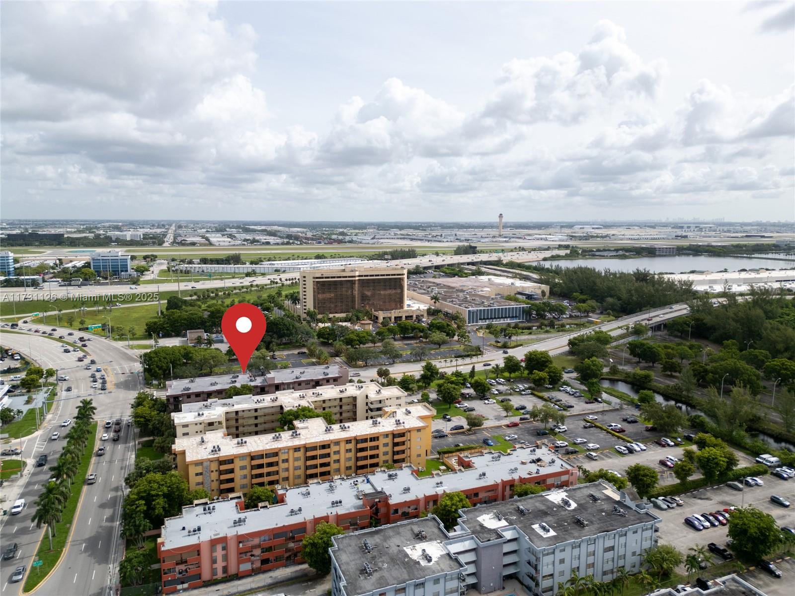An aerial view shows several multi-story apartment buildings with parking lots and surrounding greenery — 605 NW 72nd Ave # 406, Miami FL 33126, MIAMI, FL