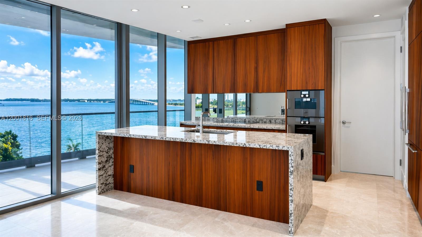 A modern kitchen features wood cabinets, granite countertops, a large island, and floor-to-ceiling water views — 175 SE 25 RD # 504, Miami FL 33129, MIAMI, FL