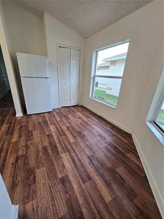 A room with wood-look flooring, a white refrigerator, a closet, and two windows — 12932 FIELDMOOR COURT, RIVERVIEW, FL