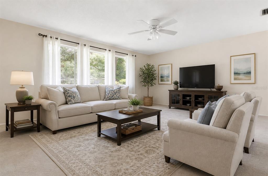 A living room features a beige sofa, two armchairs, a coffee table, and a television — 1904 GRANADA COURT, CLEARWATER, FL