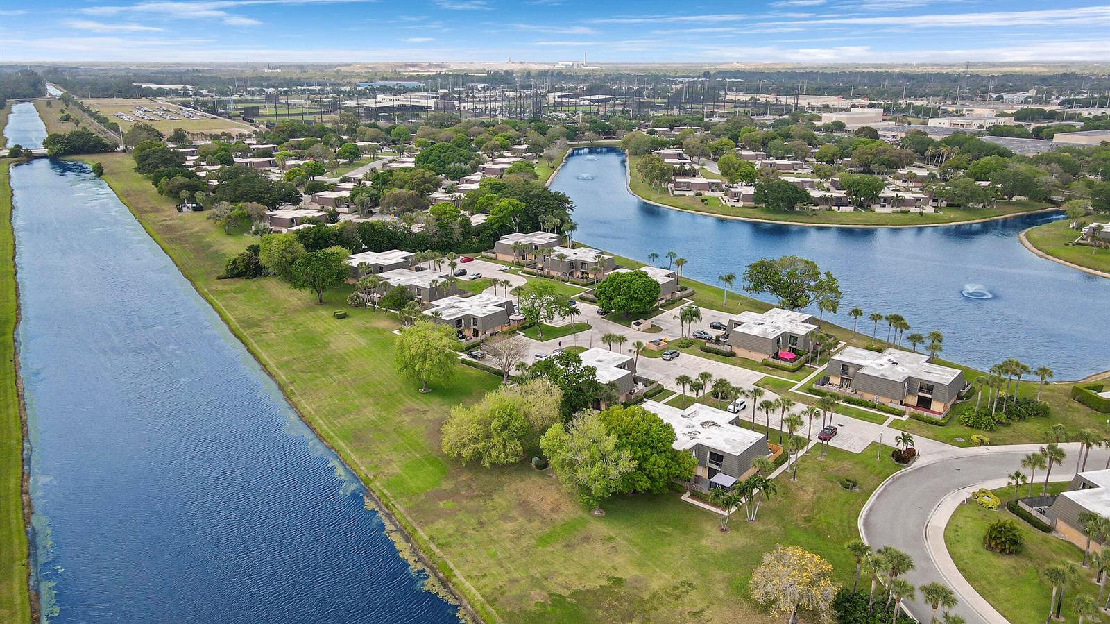 An aerial view shows residential buildings situated between a long canal and a large pond — 2404 24th Way, West Palm Beach FL 33407, WEST PALM BEACH, FL