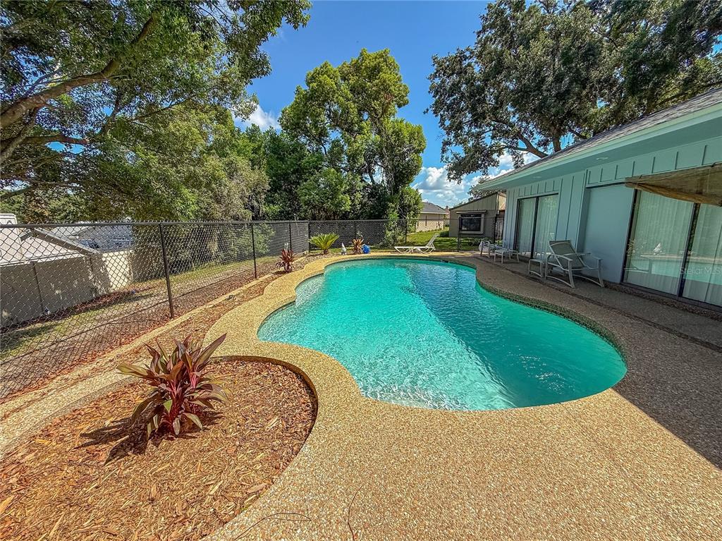 An entryway features a white front door, a side window, and a small white side table — 34007 SABAL WAY, LEESBURG, FL