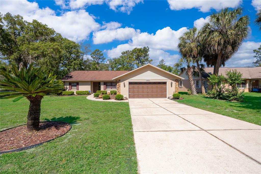 A single-story house with a brown roof, tan siding, and a two-car garage — 14604 SW 45TH COURT, OCALA, FL