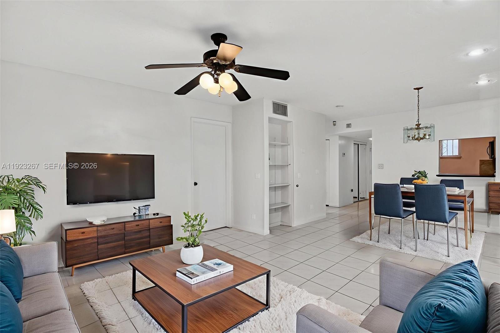 A living and dining area features white tile floors, a ceiling fan, and modern furniture — 11309 SW 200th St # C, Miami FL 33157, MIAMI, FL