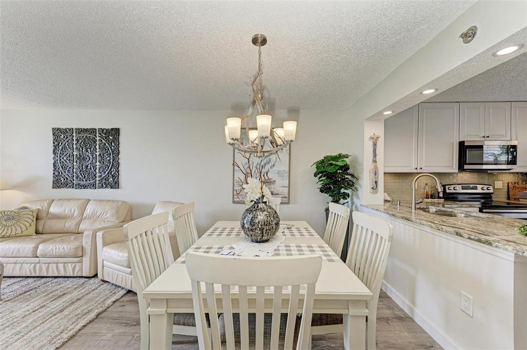A dining area with a white table and chairs sits adjacent to a kitchen counter — 4480 FAIRWAYS BOULEVARD UNIT 109, BRADENTON, FL