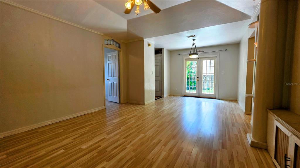 A living room with light wood flooring, a tray ceiling, and glass doors to the outside — 3741 NW 59TH PLACE, GAINESVILLE, FL