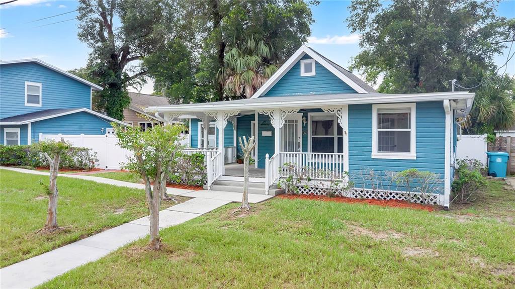 A blue single-story house with a white front porch and a sidewalk leading to it — 1512 OREGON STREET, ORLANDO, FL