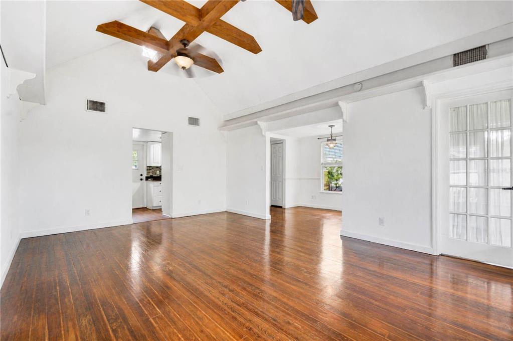 A bright living room features hardwood floors, a vaulted ceiling with exposed beams, and French doors — 1512 OREGON STREET, ORLANDO, FL