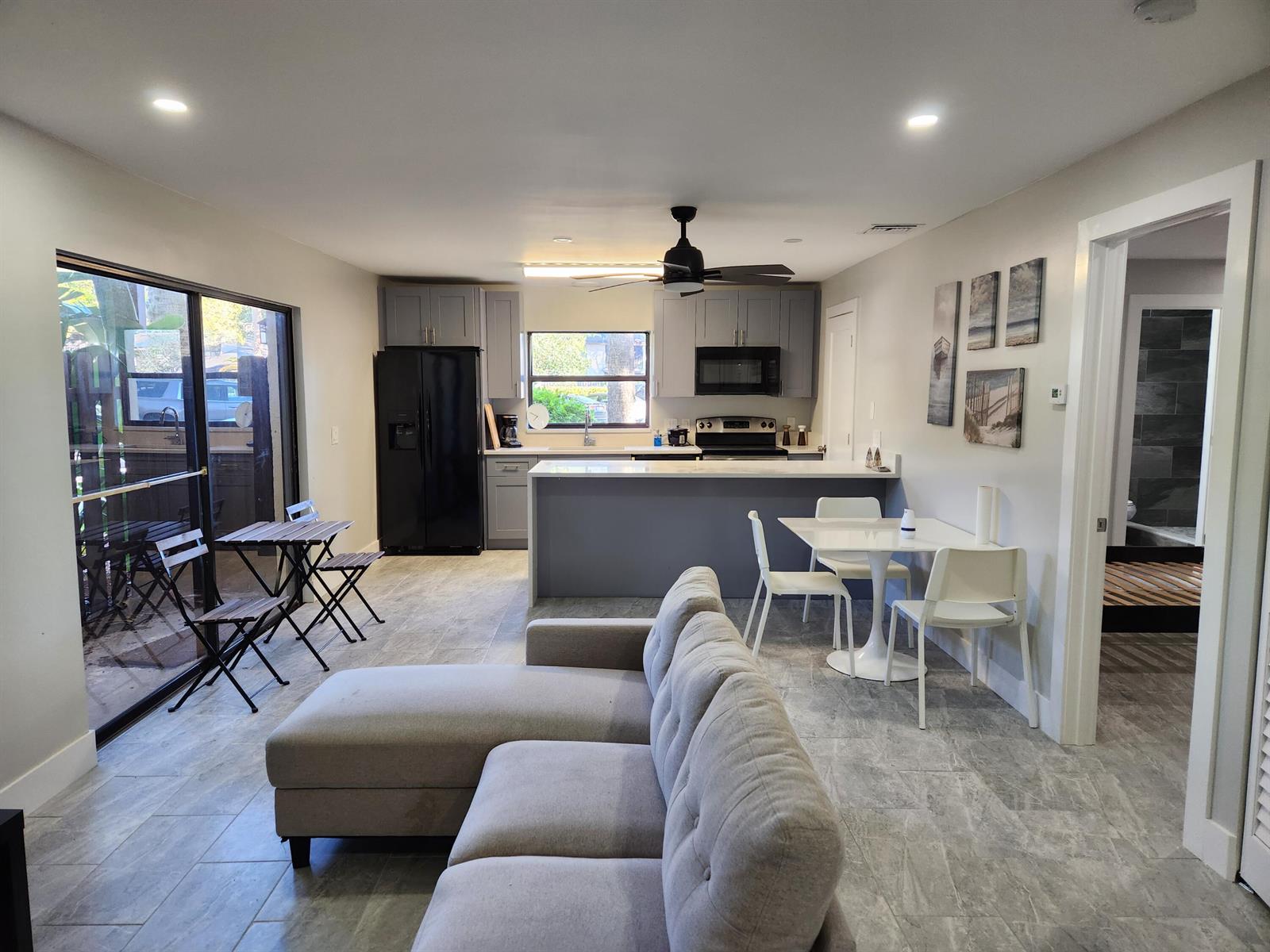 An open-concept living area features a gray kitchen, a sectional sofa, and a dining set — 2050 Oleander Boulevard # 109, Fort Pierce FL 34950, FORT PIERCE, FL
