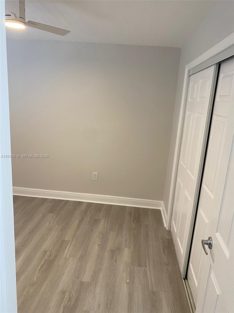 This room features light gray walls, wood-look flooring, a ceiling fan, and a sliding closet — 4650 W Flagler St # 3, Miami FL 33134, MIAMI, FL