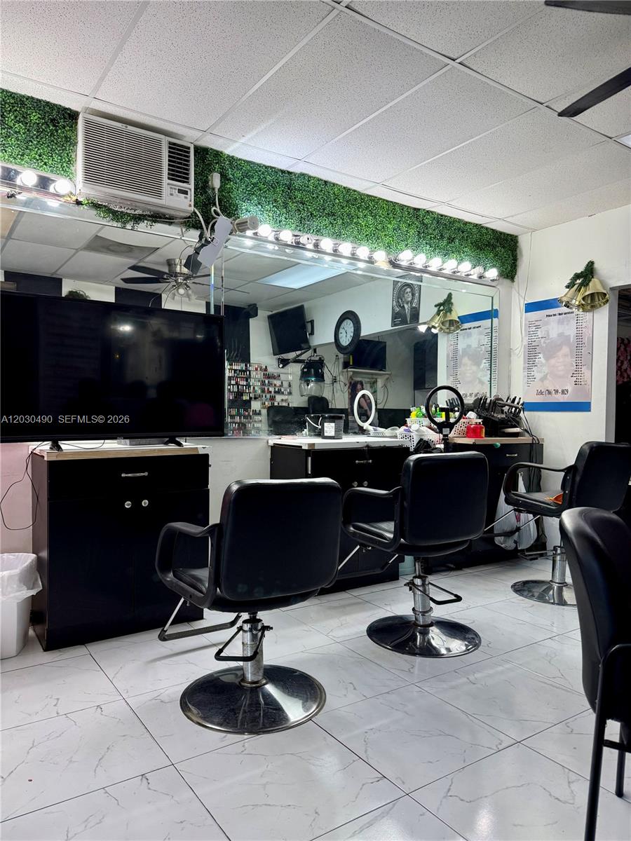 A hair salon features three black styling chairs, a large mirror, and a television — 11842 W Dixie Hwy, Miami FL 33161, MIAMI, FL
