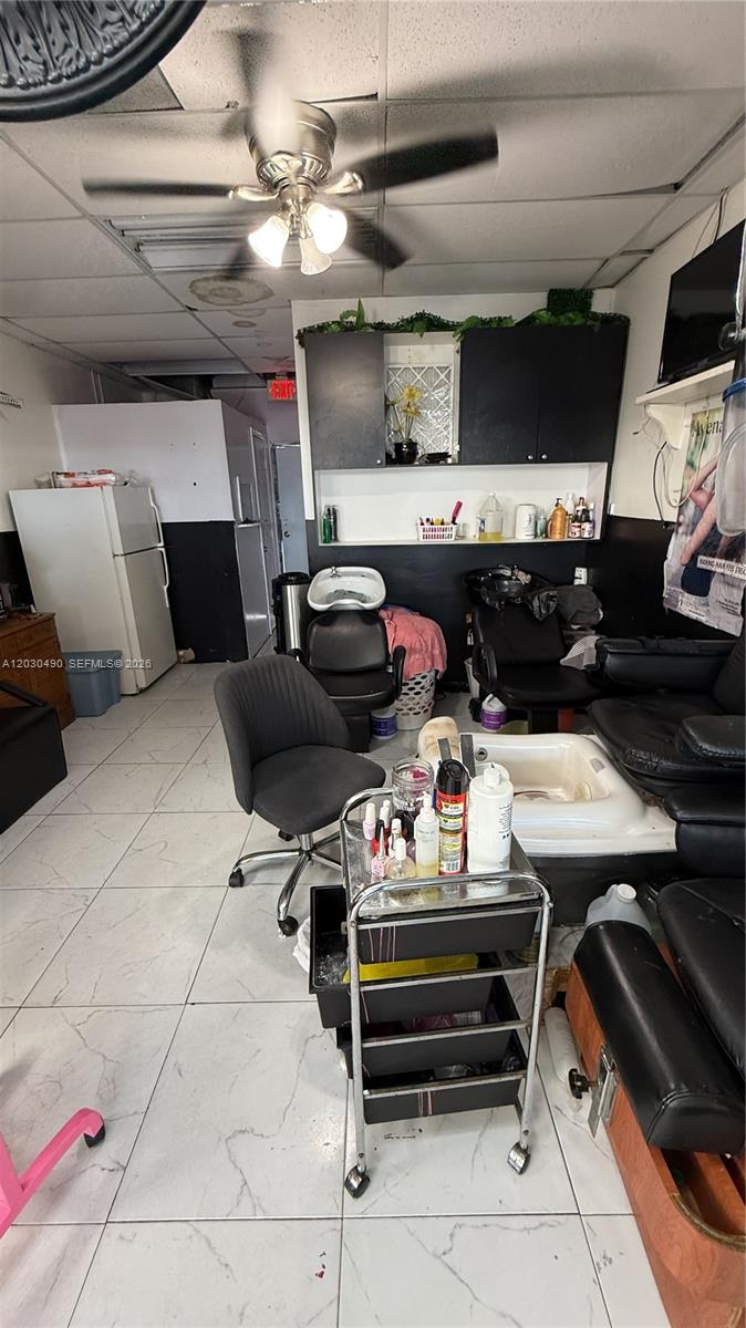 A small salon interior features a rolling cart, shampoo bowls, and black styling chairs — 11842 W Dixie Hwy, Miami FL 33161, MIAMI, FL