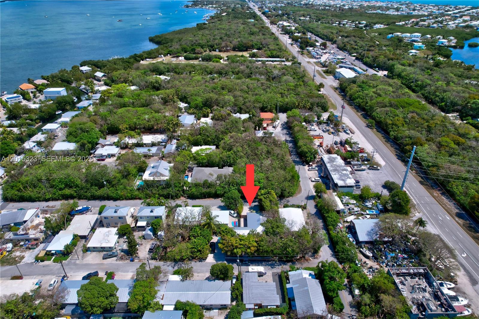 An aerial view shows a residential property marked by a red arrow among trees — 85 Henry Morgan Dr, Key Largo FL 33037, KEY LARGO, FL