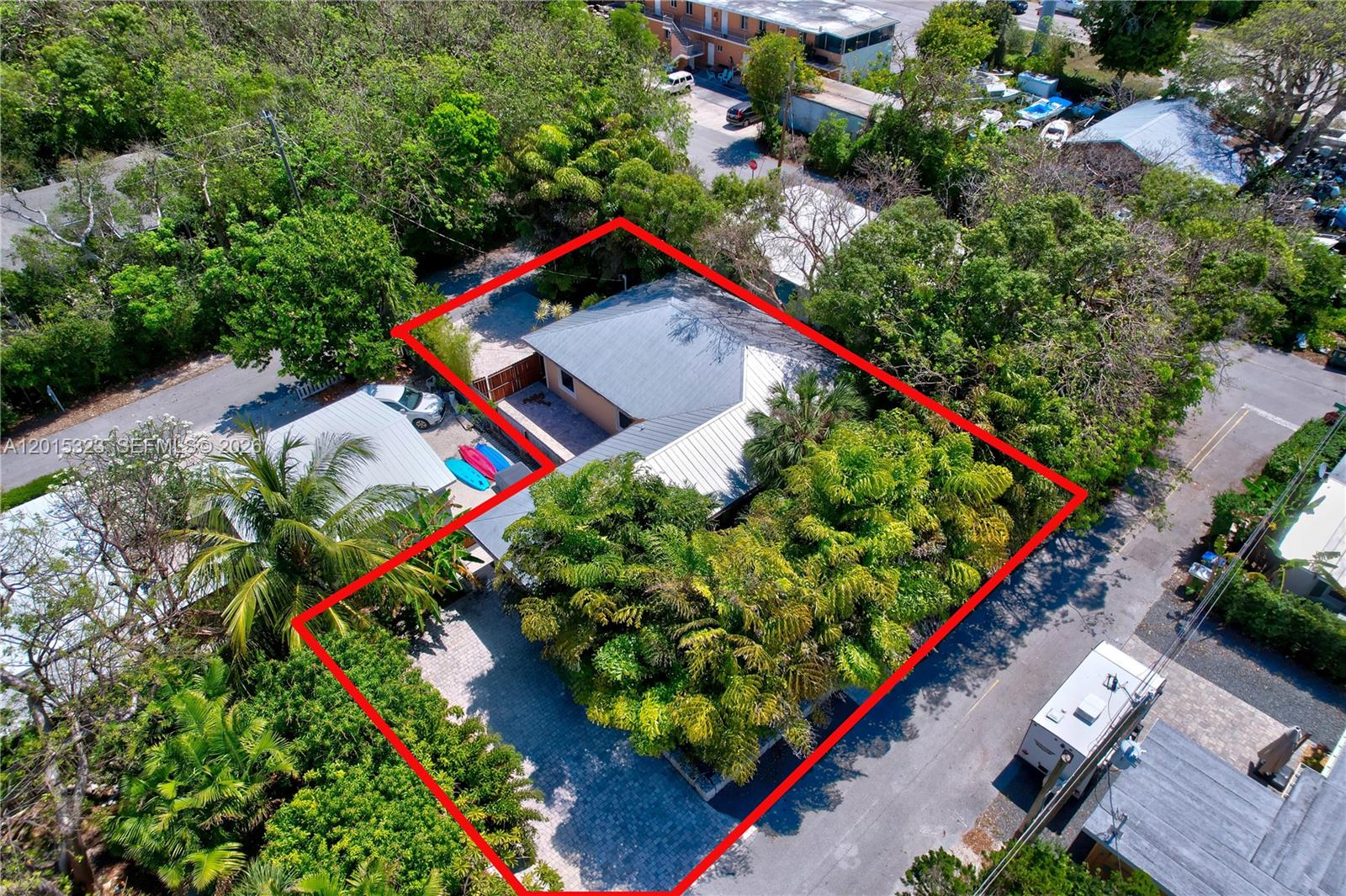 An aerial view shows a house with a metal roof surrounded by dense trees — 85 Henry Morgan Dr, Key Largo FL 33037, KEY LARGO, FL